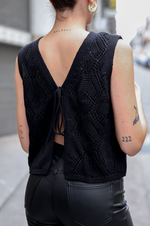 Back and tie detail of fashion-forward black crochet vest with breathable knit texture and elevated casual-chic silhouette.