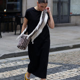 Fashion-forward black cap sleeve maxi dress with minimalist silhouette and effortless urban styling.