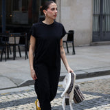 Women’s minimalist black maxi dress with relaxed drape and chic off-duty model style appeal.