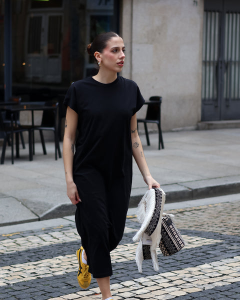 Women’s minimalist black maxi dress with relaxed drape and chic off-duty model style appeal.