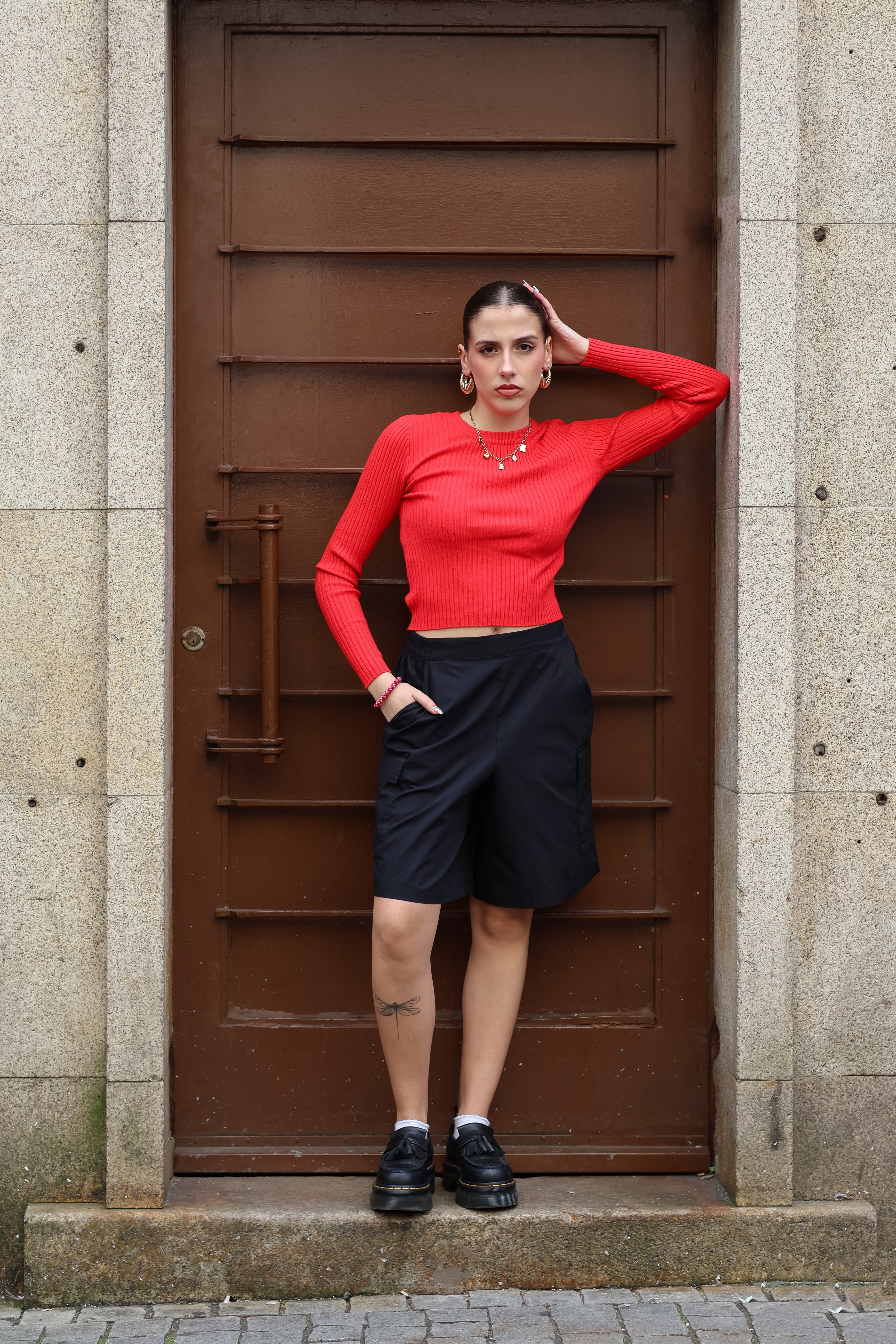 Women’s red ribbed knit crop sweater with fitted silhouette and trendy minimalist street style fashion.