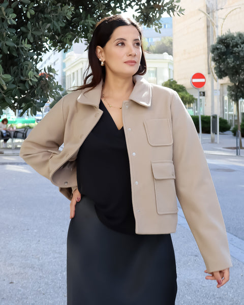 Chic women’s beige wool-blend jacket layered over a sleek black midi dress for elevated everyday sophistication.