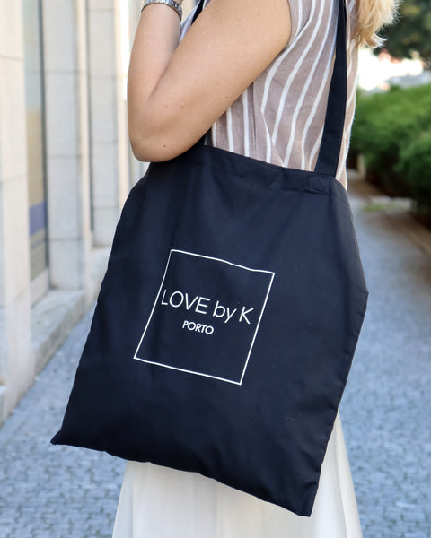 Large black shopper tote with contemporary logo Love By K design and functional minimalist fashion appeal.