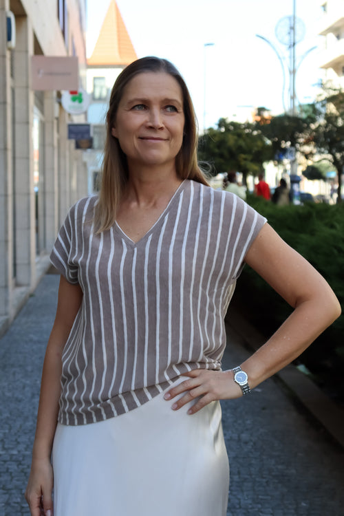 Chic neutral striped blouse featuring soft knit fabric, cap sleeves, and modern casual-luxe styling for women.