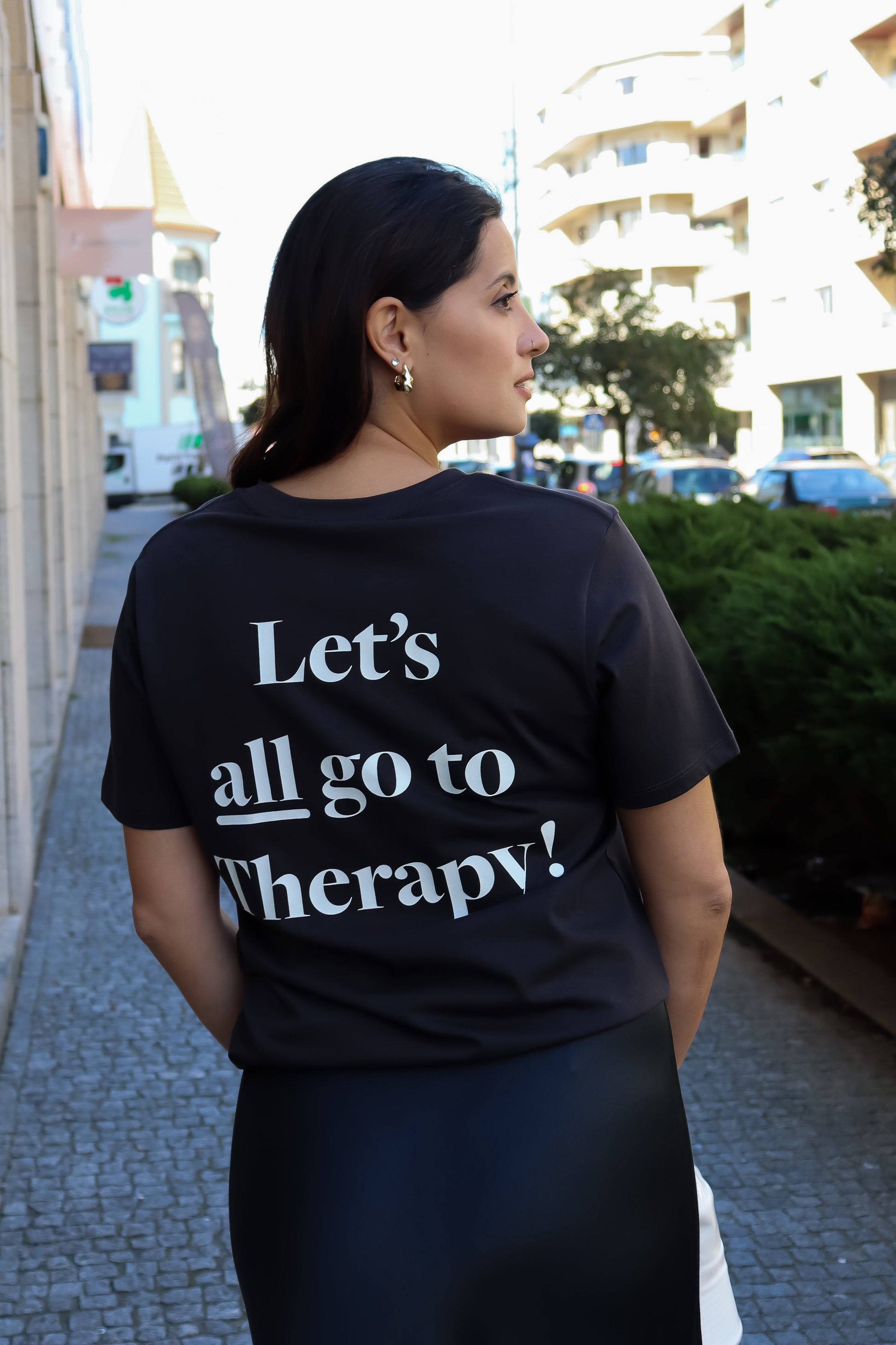 Trendy black statement tee for women featuring “Let’s all go to Therapy!” graphic and casual urban fashion style.