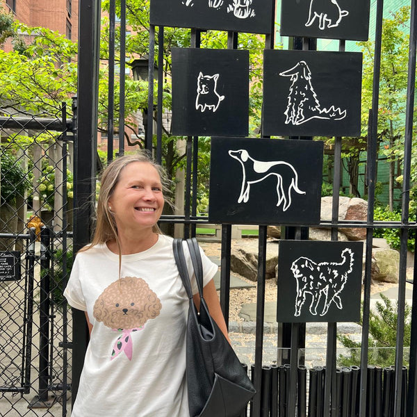 Women’s white graphic T-shirt with cute dog print and rolled short sleeves for casual everyday outfits and pet lover fashion.