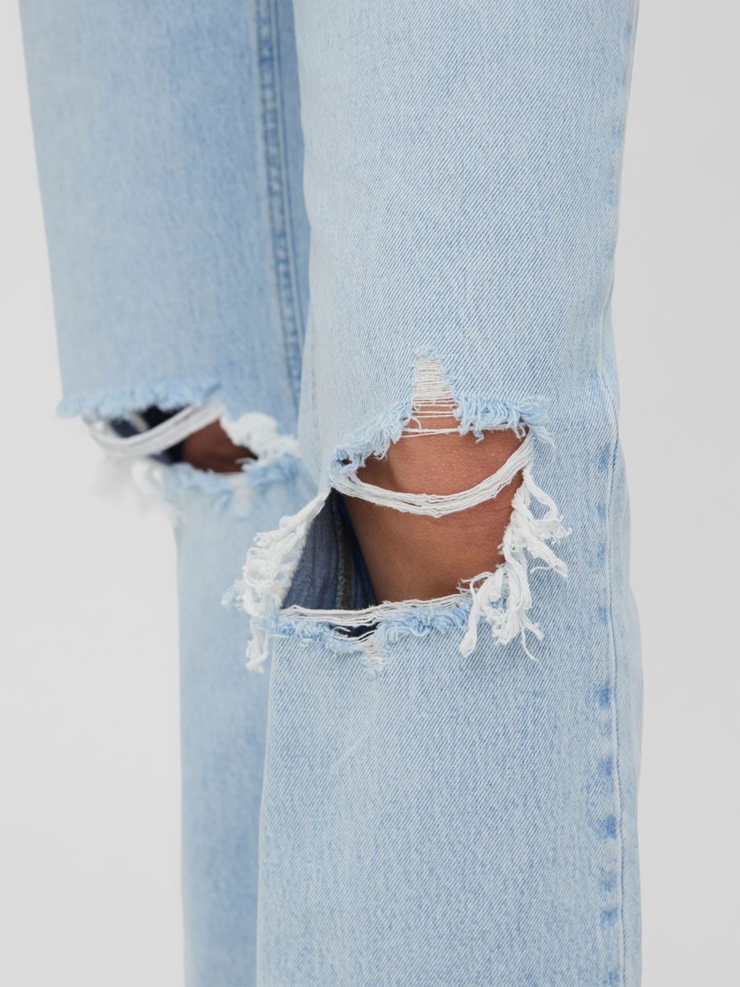 Casual light blue denim jeans featuring vintage-inspired fading and trendy knee distressing.
