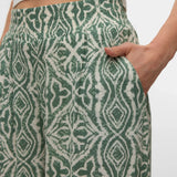 Casual chic sage green trousers featuring side pockets, flowing fabric, and an elegant drape.