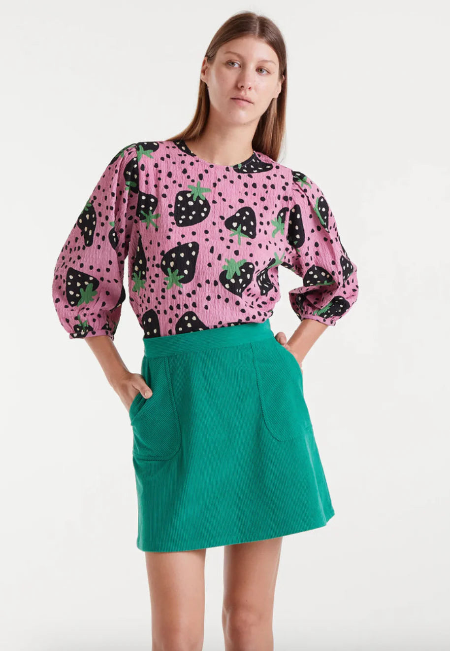 Women's pink strawberry print blouse with black fruit motifs, green accents and three-quarter balloon sleeves for playful statement style.