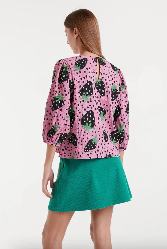 Bright pink printed blouse with black and green strawberry pattern and statement puff sleeves for contemporary casual styling.