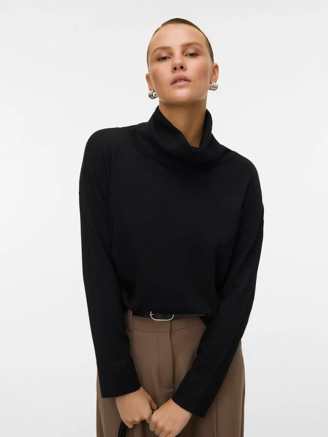Women's minimalist black roll-neck sweater featuring a relaxed silhouette for versatile work, travel and everyday styling.
