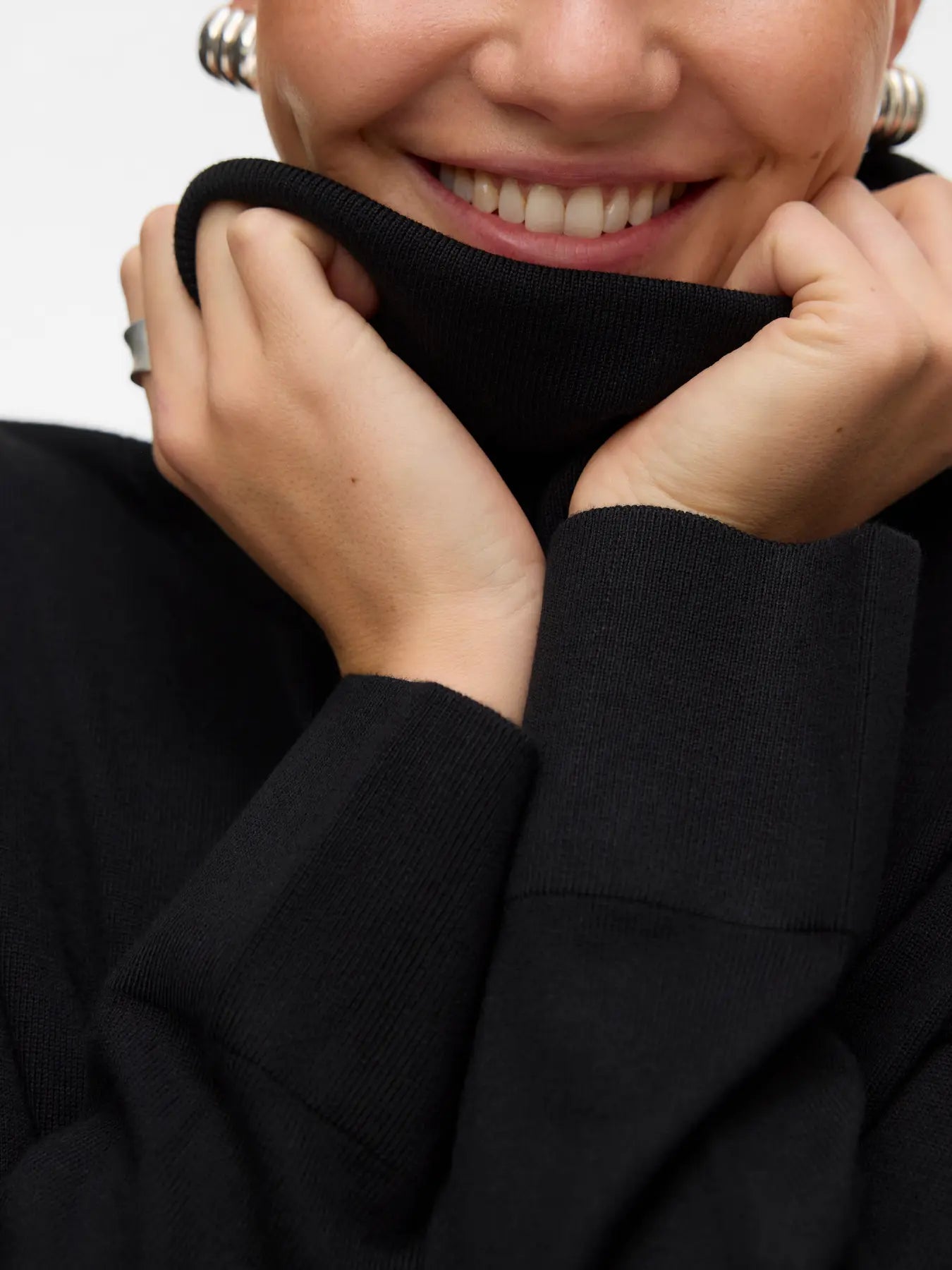 Women's timeless black roll-neck sweater with long sleeves and relaxed fit for an elevated capsule wardrobe.
