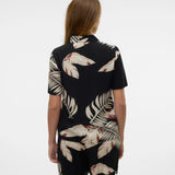 Back view of contemporary palm leaf blouse in black and cream with chic island-inspired fashion vibe.