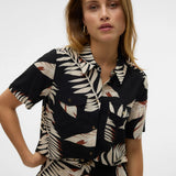 Trendy resort-style cropped shirt with tropical foliage pattern and effortless coastal chic appeal.