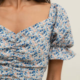 Women's blue floral midi dress with puff sleeves, sweetheart neckline, and elegant front slit.