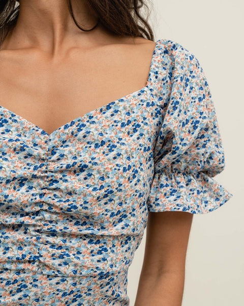 Women's blue floral midi dress with puff sleeves, sweetheart neckline, and elegant front slit.