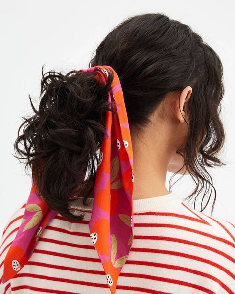 Women's fruit print scarf scrunchie in vibrant pink and orange with long ribbon tails.