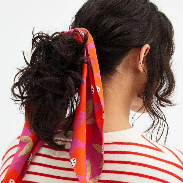 Women's fruit print scarf scrunchie in vibrant pink and orange with long ribbon tails.