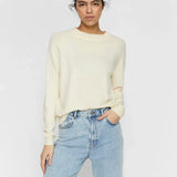 Soft cream long sleeve knit sweater for women featuring a minimalist casual chic silhouette.