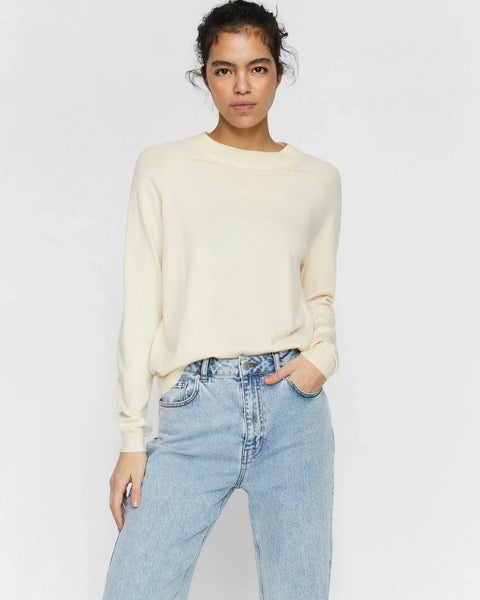 Soft cream long sleeve knit sweater for women featuring a minimalist casual chic silhouette.