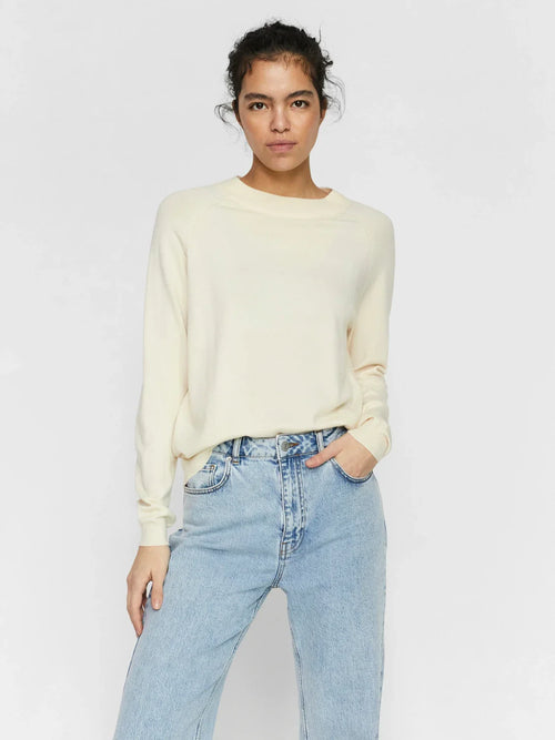 Soft cream long sleeve knit sweater for women featuring a minimalist casual chic silhouette.