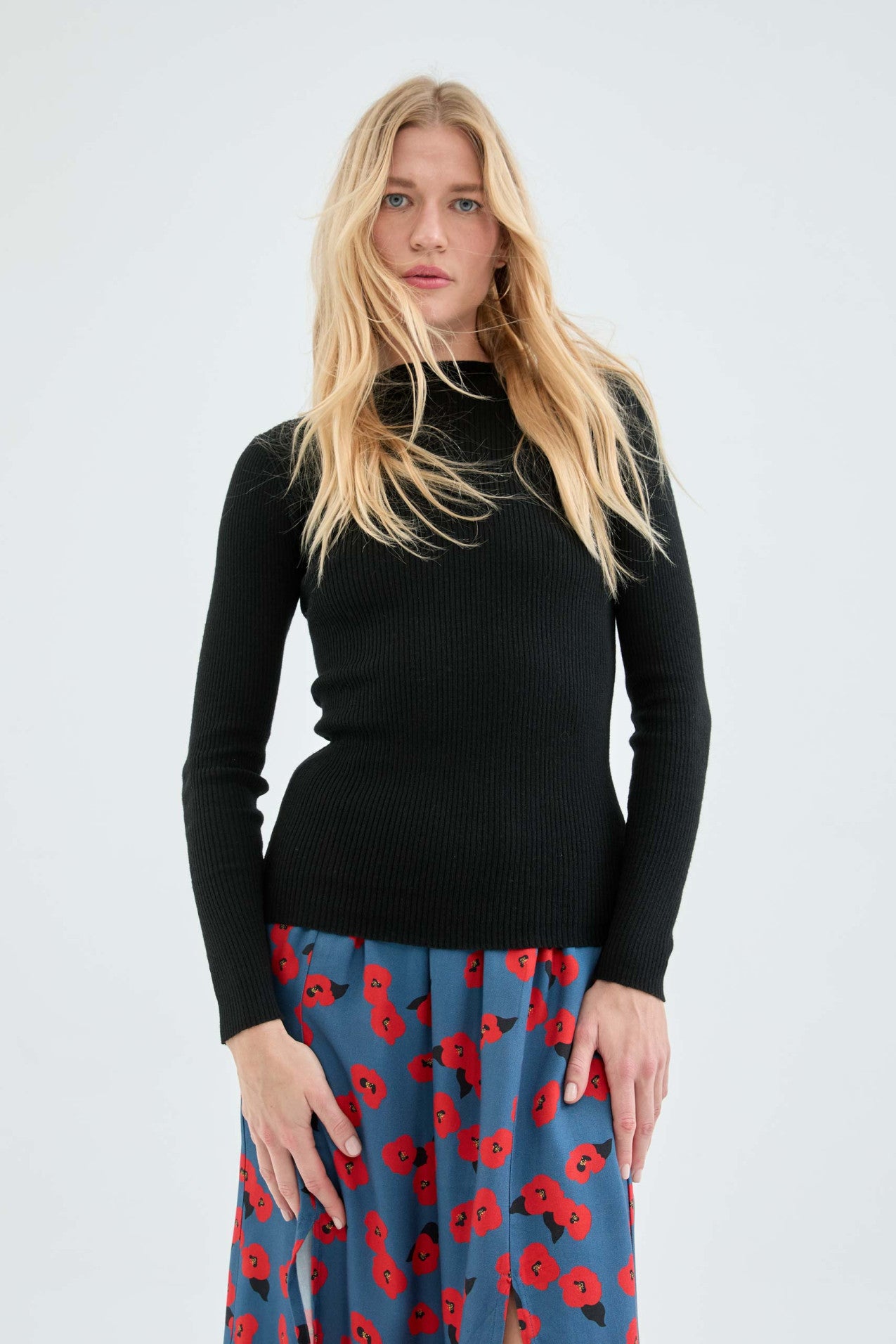 Soft black ribbed knit sweater with long sleeves and flattering slim silhouette for trendy capsule wardrobe styling.