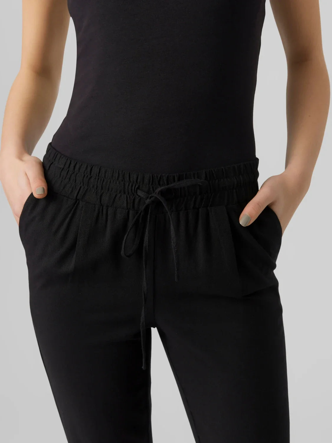 Women's black drawstring pants with tapered leg and elastic waistband.