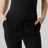 Women's black drawstring pants with tapered leg and elastic waistband.