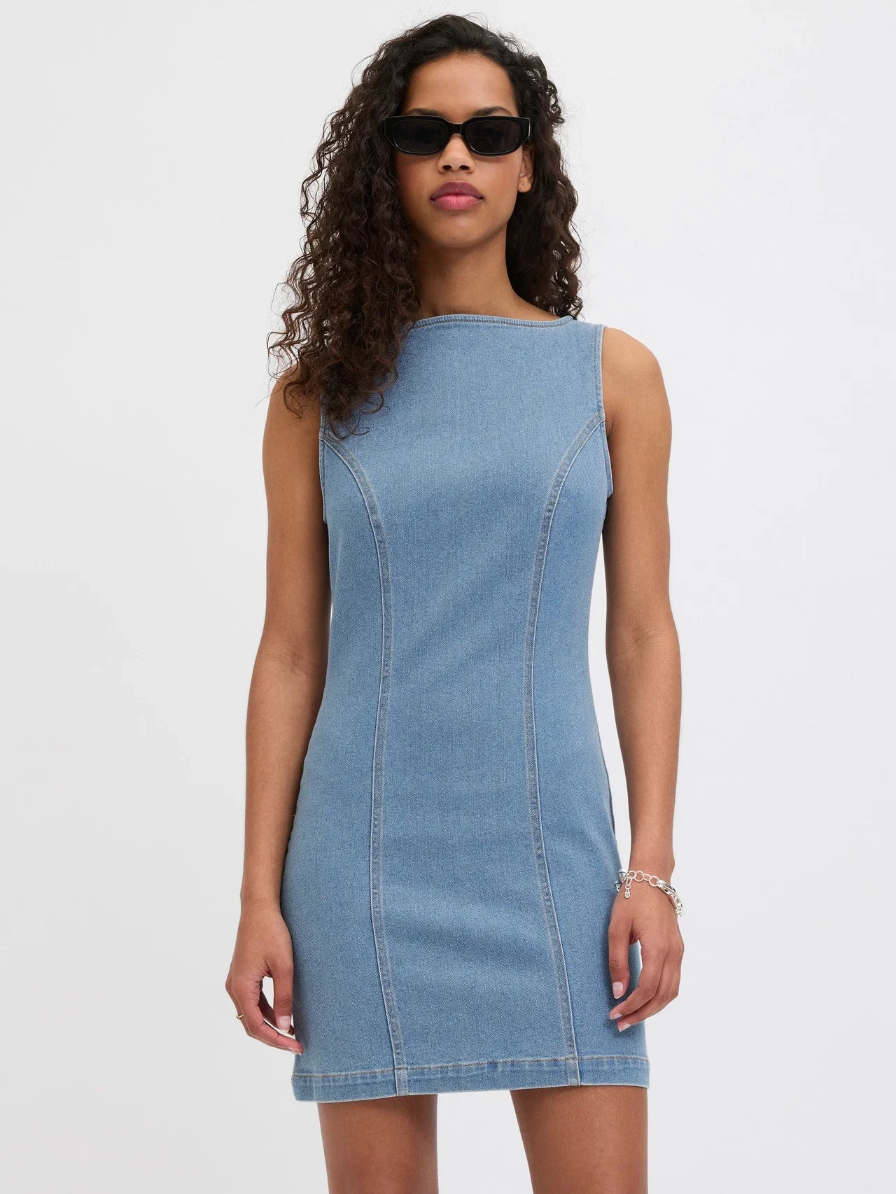Women’s light wash denim mini dress with sleek minimalist silhouette and modern cool-girl styling.