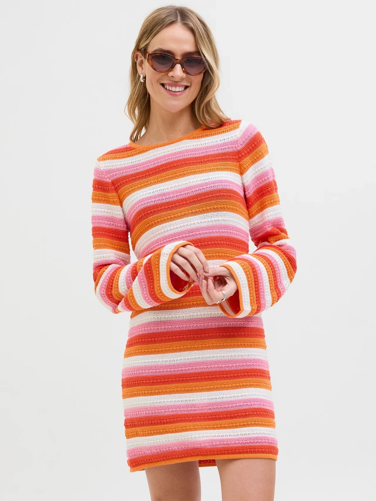Trendy crochet-inspired striped sweater dress with bell sleeves and playful Y2K fashion vibe.