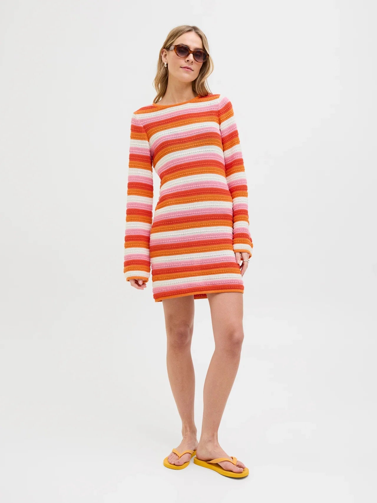 Trendy crochet-inspired striped sweater dress with bell sleeves and playful Y2K fashion vibe.