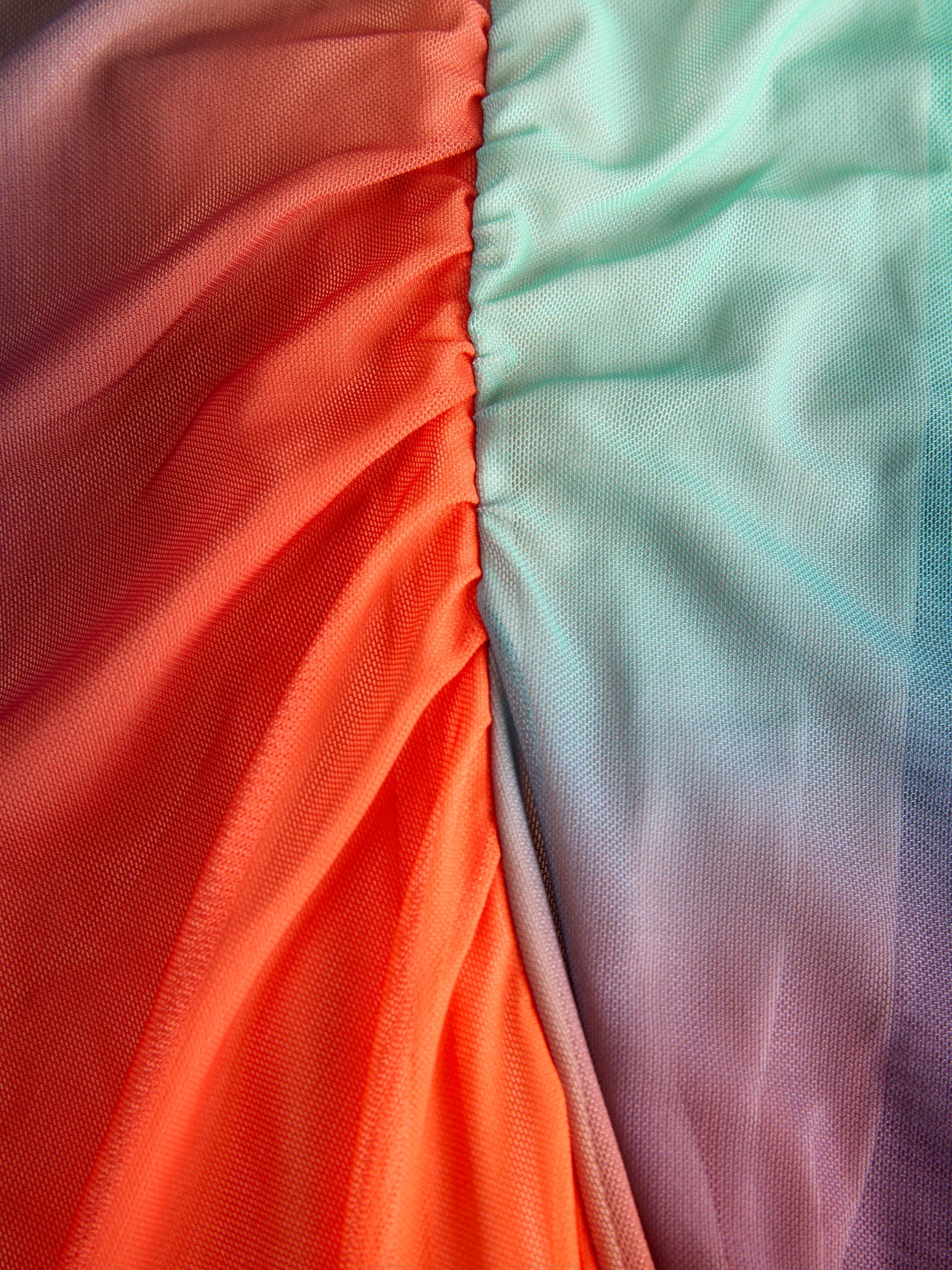 Detail of material of this women’s ombré mesh maxi dress with sunset gradient tones and modern resortwear aesthetic.