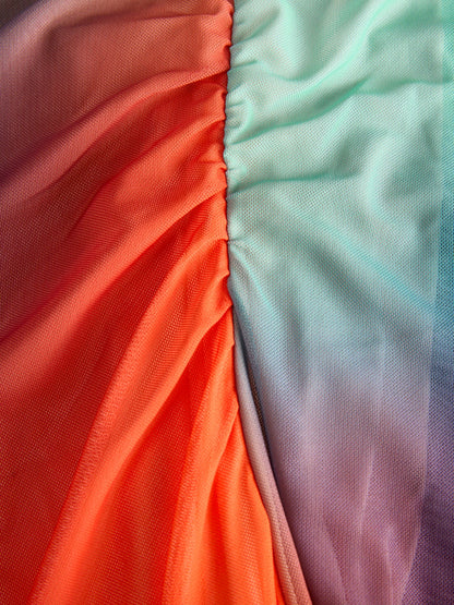 Detail of material of this women’s ombré mesh maxi dress with sunset gradient tones and modern resortwear aesthetic.