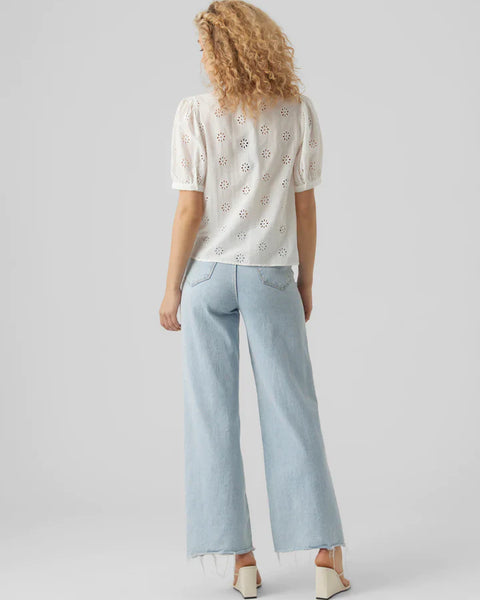 Feminine white broderie anglaise top with puff sleeves and floral embroidery accents.