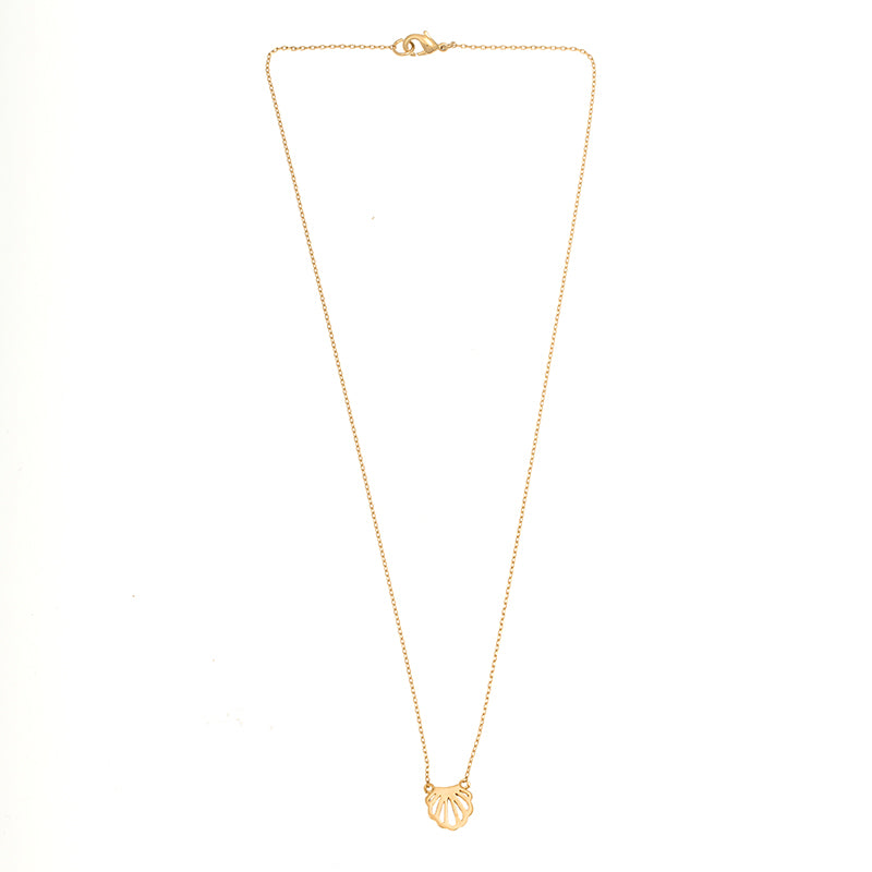 Gold seashell charm necklace with understated luxury and trendy layered necklace look.