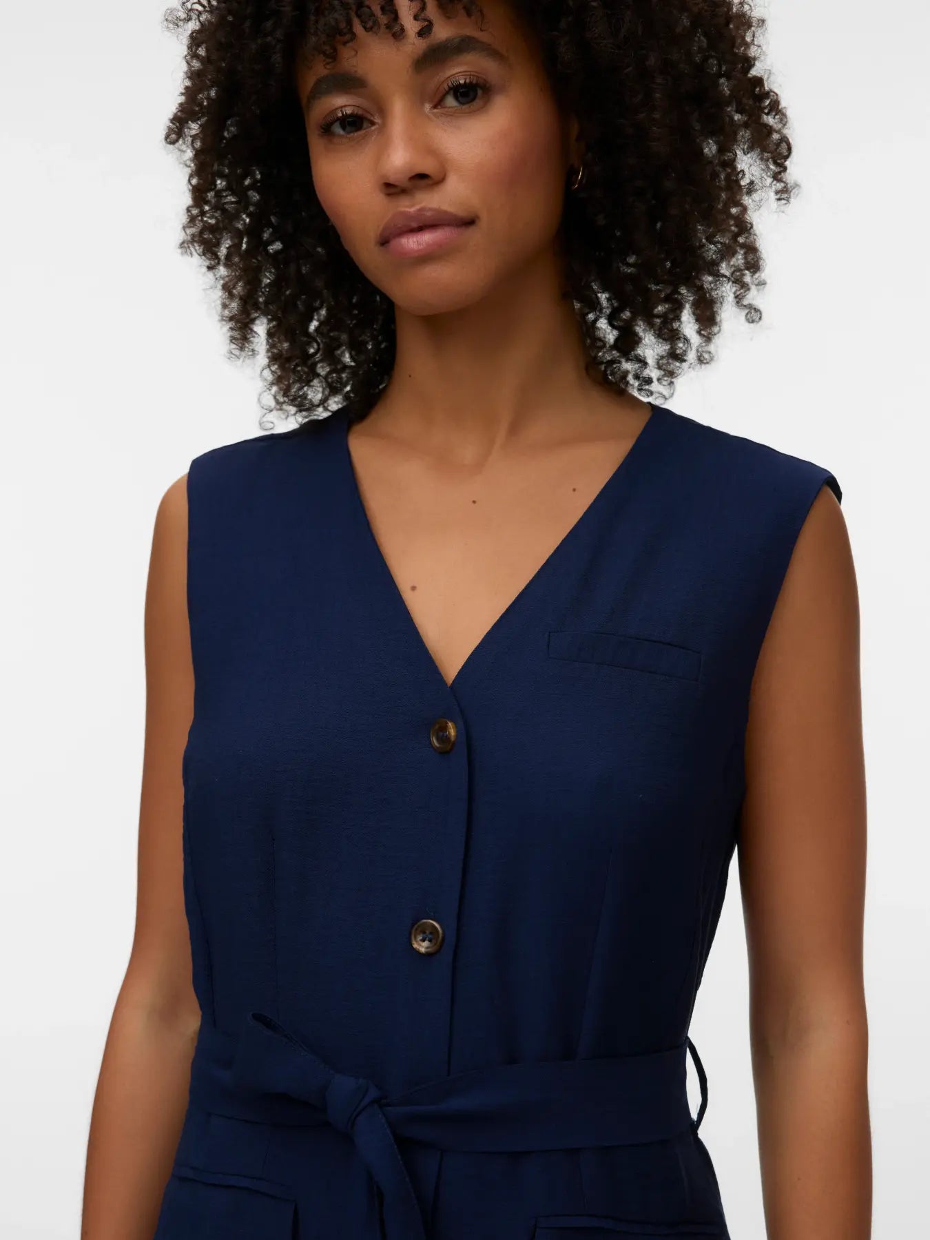 Versatile navy sleeveless dress with waist tie and button-front closure for elevated smart casual outfits.