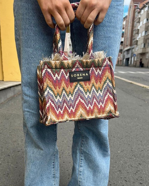 Women's woven handbag with ethnic print and trendy boutique fashion appeal.