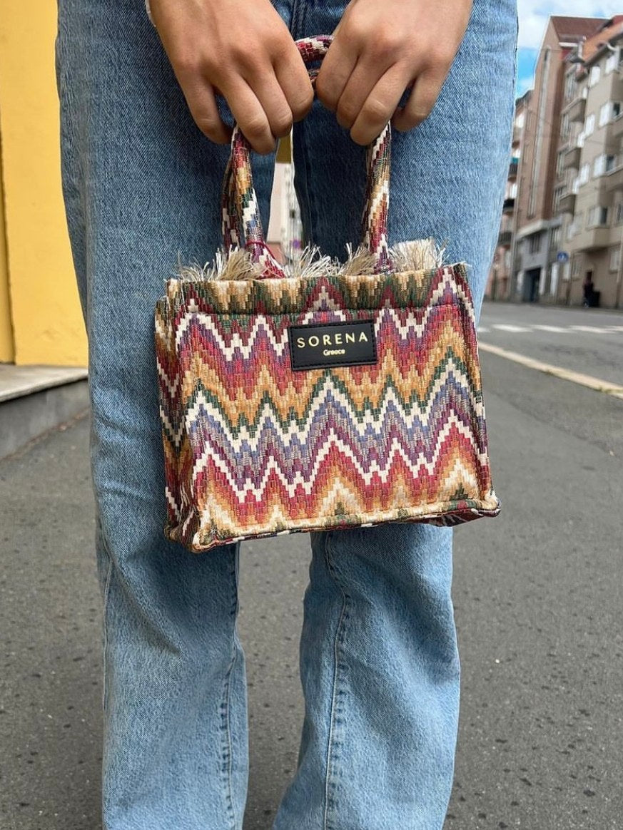 Women's woven handbag with ethnic print and trendy boutique fashion appeal.
