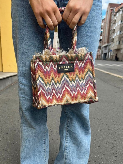 Women's woven handbag with ethnic print and trendy boutique fashion appeal.