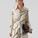 Contemporary abstract print blouse in cream and black with classic collar and relaxed fit for timeless sophisticated style.