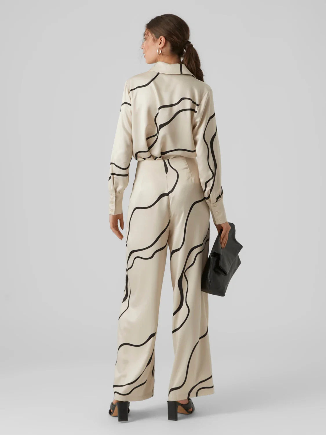Women’s luxury-inspired cream blouse with flowing black abstract pattern and silky button-up construction for elegant fashion outfits.