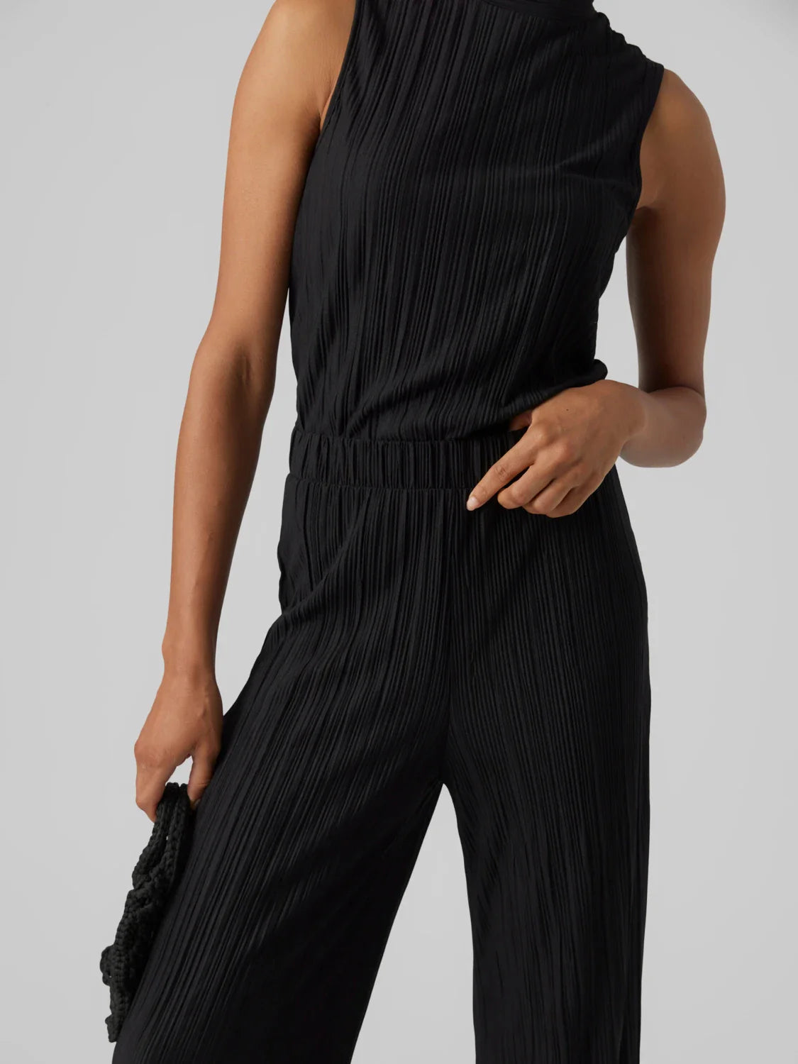 Women’s modern black flowy pants with elastic waist and sophisticated pleated fabric finish.
