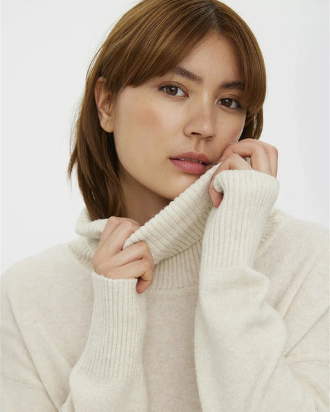 Cozy cream oversized sweater with ribbed turtleneck and effortless minimalist cold-weather style aesthetic.