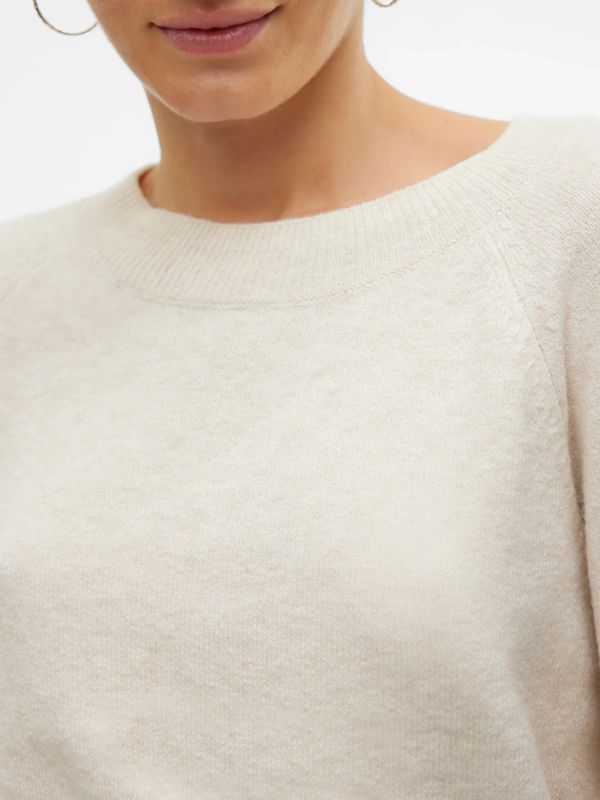 Women’s neutral cream crew-neck sweater for versatile casual outfits with jeans, trousers, and skirts.