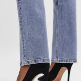 Detail of hem of minimalist straight leg jeans in light blue wash with flattering tailored fit for trendy capsule wardrobe fashion.
