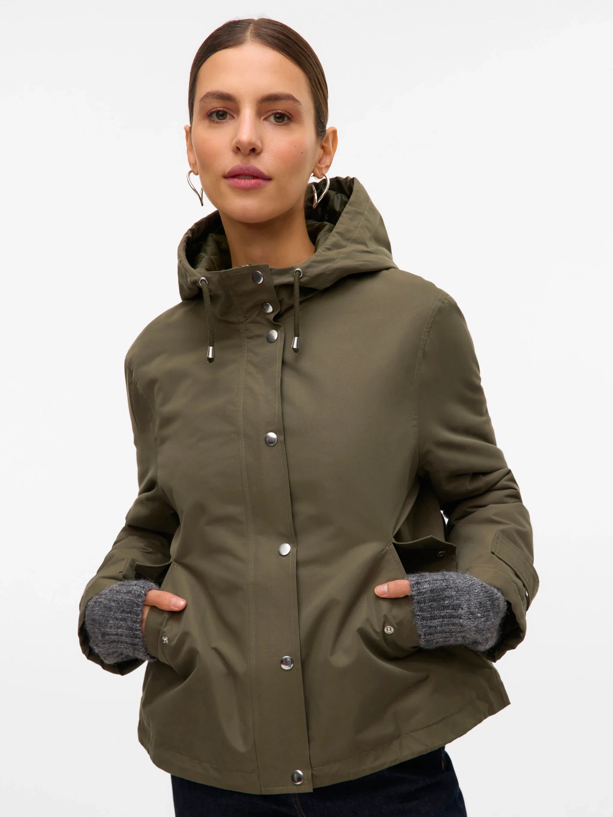 Olive green hooded utility coat for women with relaxed fit and functional pockets for casual travel and transitional weather.