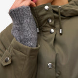 Detail of silver buttons and drewstring hood of this chic weather-resistant women’s jacket with minimalist silhouette and elevated off-duty fashion.