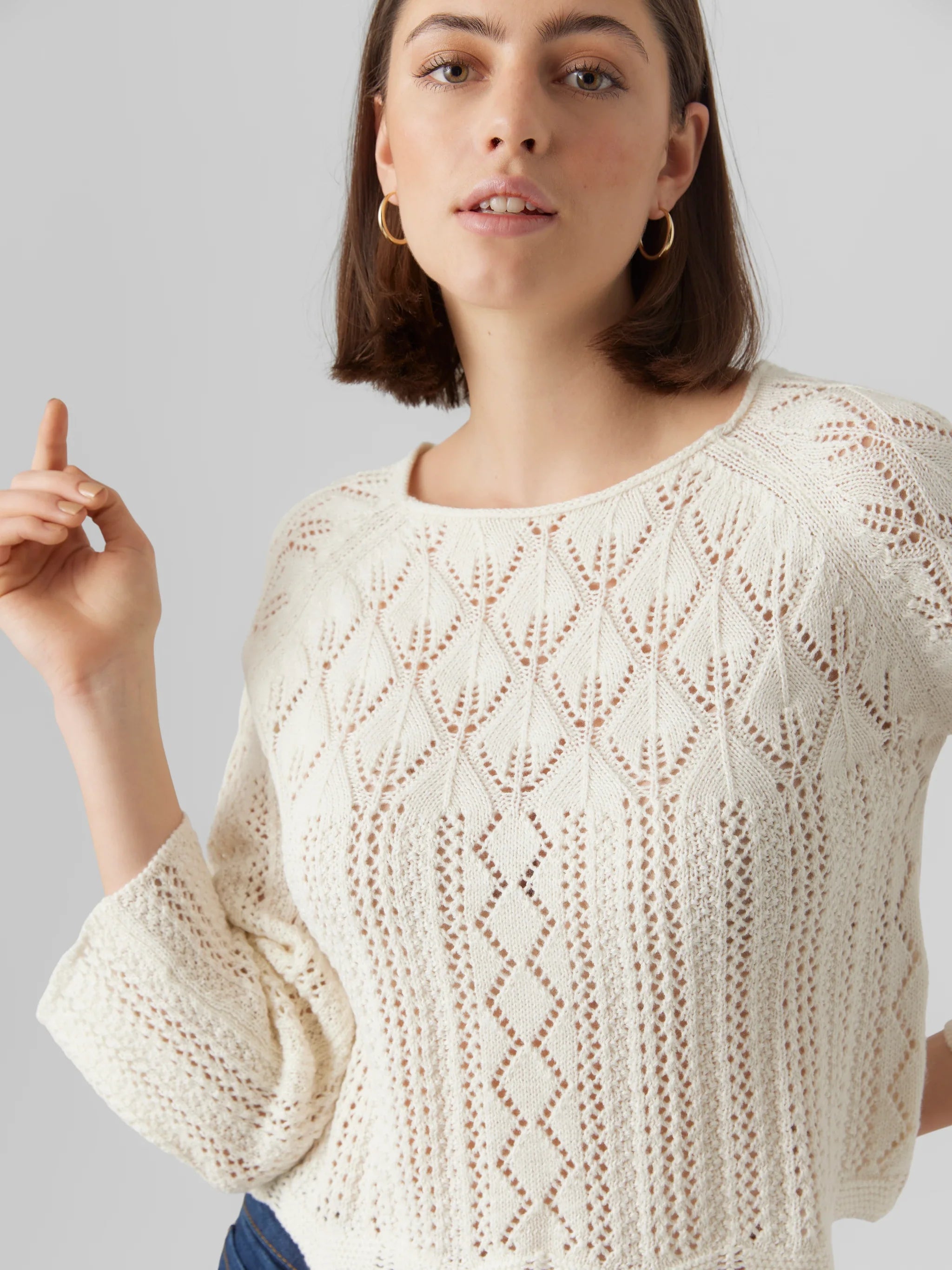 Women’s ivory pointelle knit sweater with boho chic style and lightweight open-knit texture.
