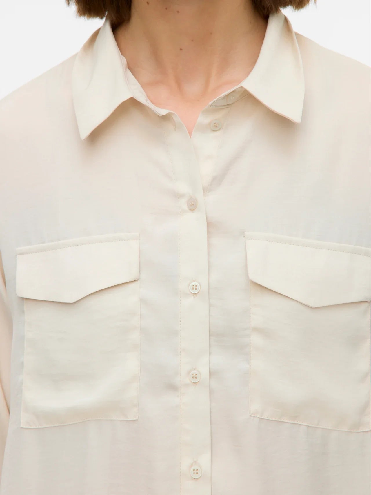 Women’s ivory collared blouse with button front and utility pocket details for modern everyday fashion.