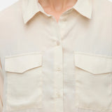 Women’s ivory collared blouse with button front and utility pocket details for modern everyday fashion.